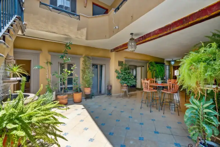 Casa Los Helechos, courtyard with a breakfast table, hanging ferns and an upper gallery with a lantern, San Miguel de Allende