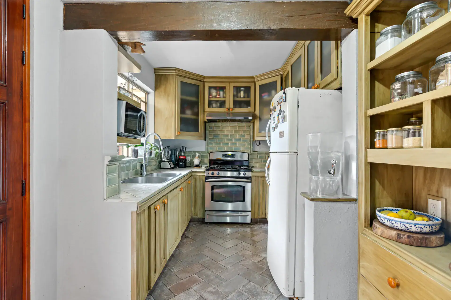 Casa Los Helechos, kitchen with wood cabinets, a stainless range and a white refrigerator, San Miguel de Allende
