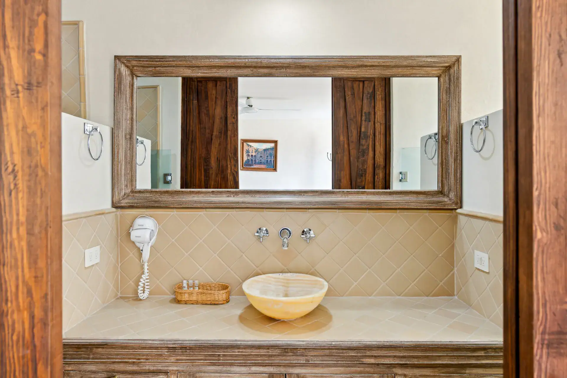 Casa Los Helechos, bathroom vanity with a stone vessel sink and a wood-framed mirror, San Miguel de Allende