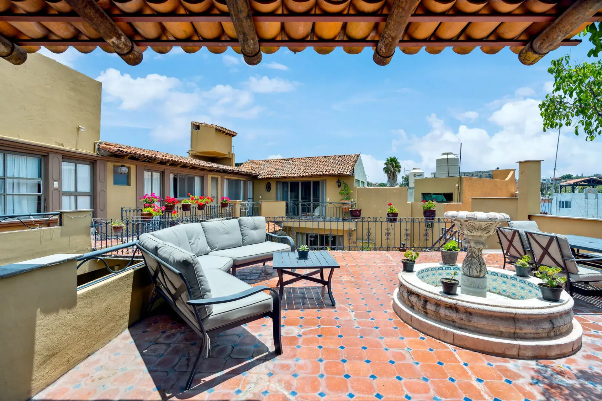 Casa Los Helechos, rooftop terrace with a curved sofa, a tiled fountain and a tile-roofed pavilion, San Miguel de Allende