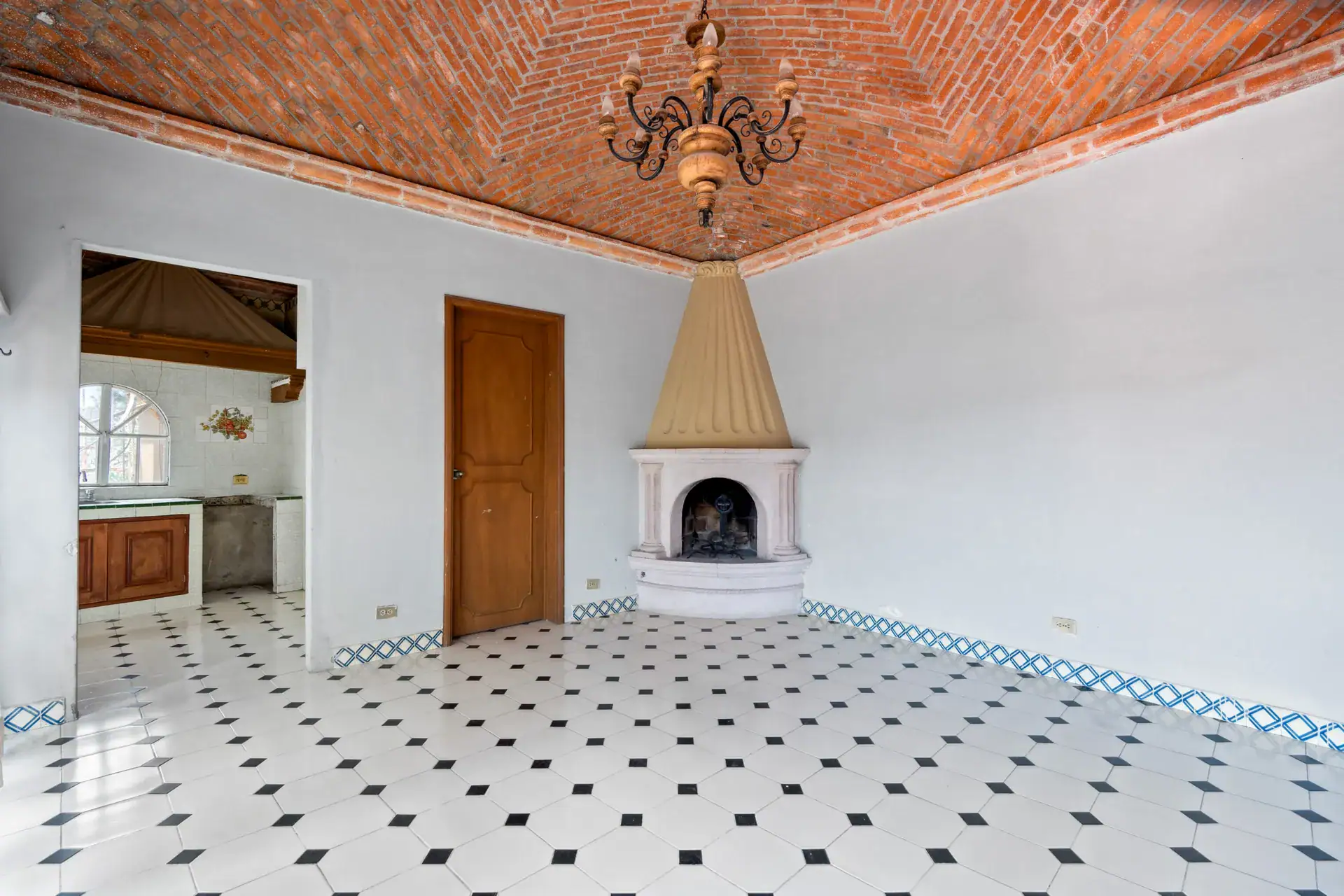 Casa Los Helechos, bright room with a brick vaulted ceiling, a corner fireplace and a checkered floor, San Miguel de Allende