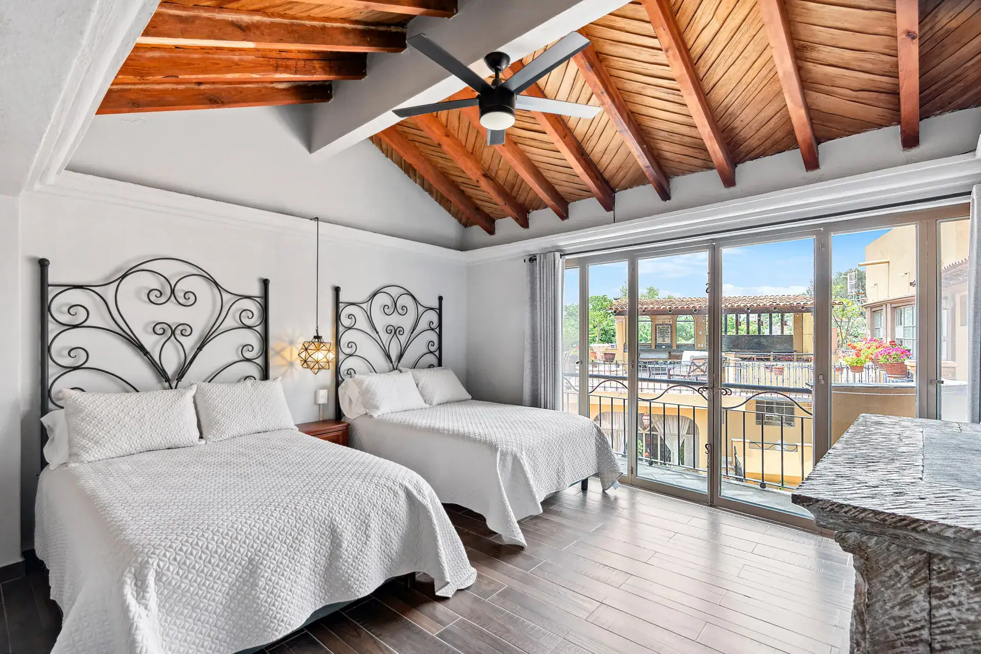 Casa Los Helechos, suite with two beds, iron headboards, a wood vaulted ceiling and a balcony, San Miguel de Allende