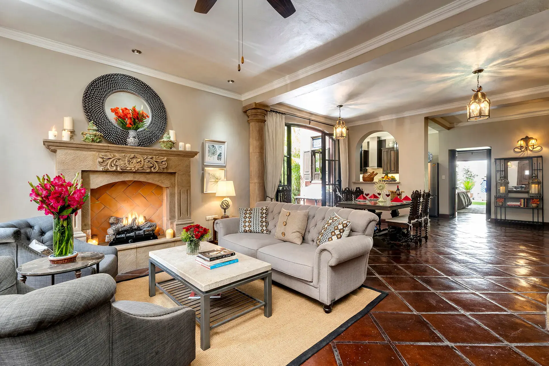 Casa Lua, living room with a stone fireplace, gray sofas and a terracotta floor, San Miguel de Allende