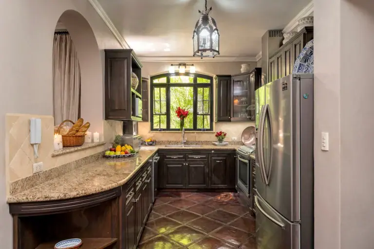 Casa Lua, kitchen with a granite counter, dark cabinets and a steel refrigerator, San Miguel de Allende