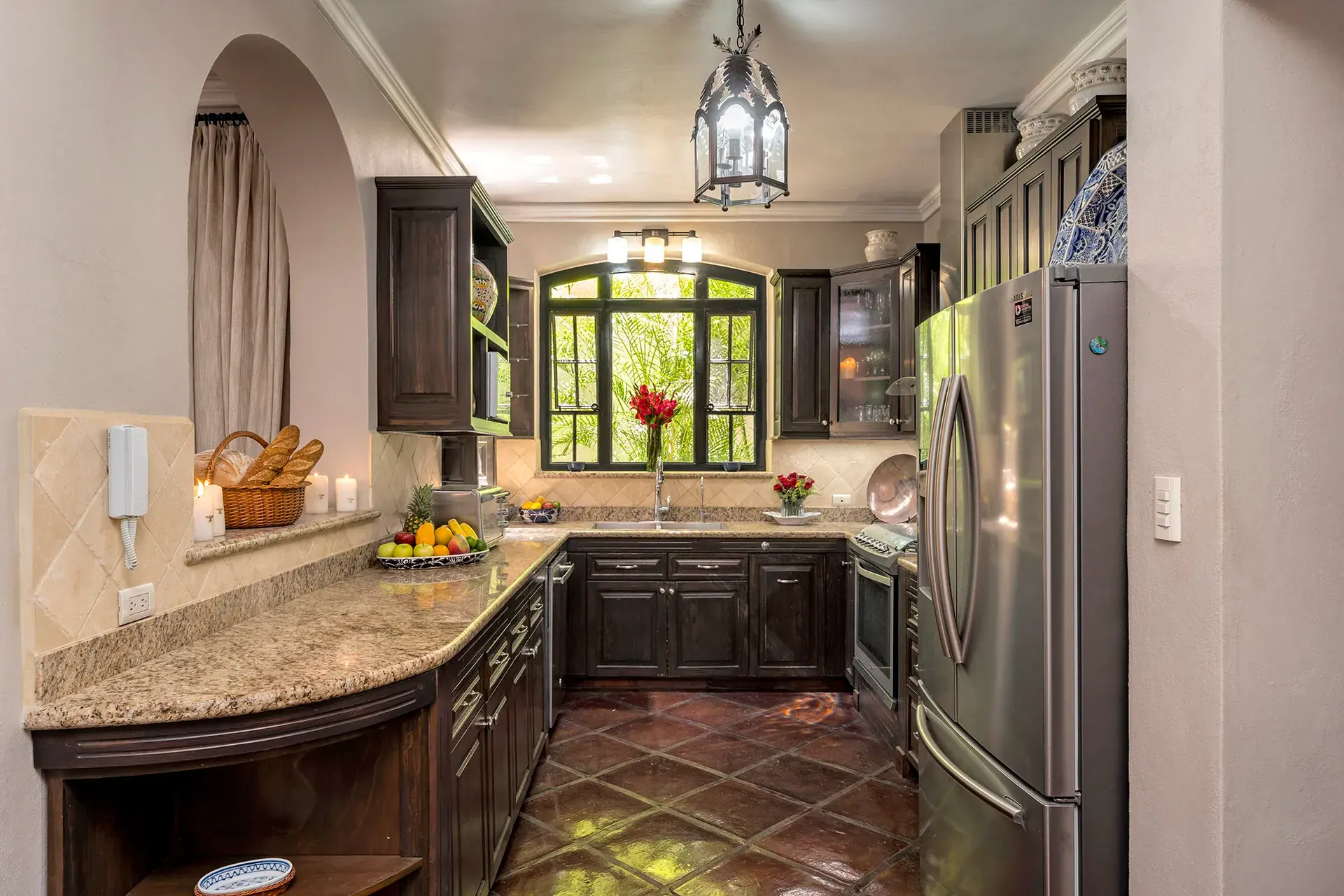 Casa Lua, kitchen with a granite counter, dark cabinets and a steel refrigerator, San Miguel de Allende