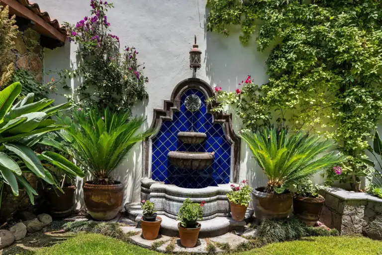 Casa Lua, garden with a blue tile fountain framed by plants, San Miguel de Allende