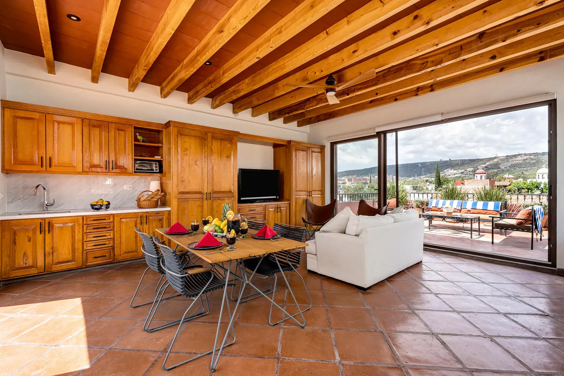 Casa Lua, upper level kitchen and dining area with wood cabinets and a terrace view, San Miguel de Allende