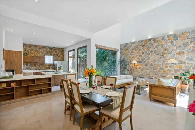 Casa Lula, open kitchen, dining and living area with a stone feature wall, San Miguel de Allende