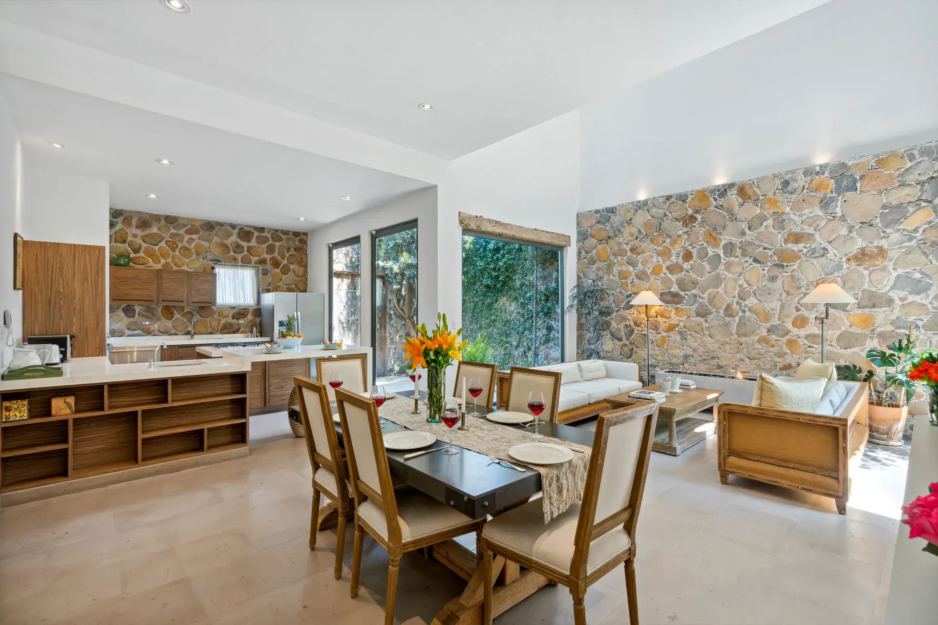 Casa Lula, open kitchen, dining and living area with a stone feature wall, San Miguel de Allende