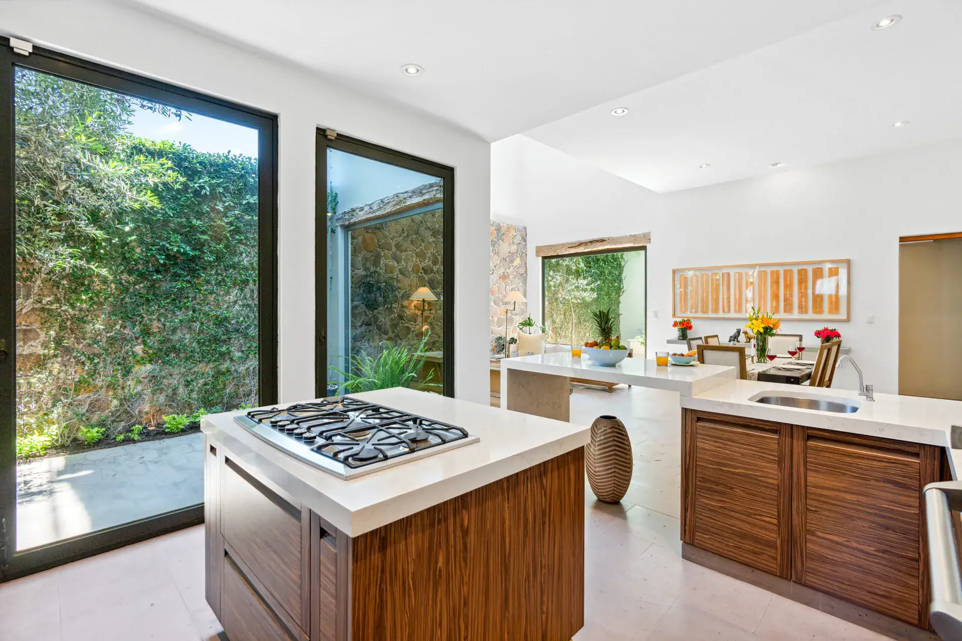 Casa Lula, kitchen island with a gas cooktop beside a glass wall to the garden, San Miguel de Allende