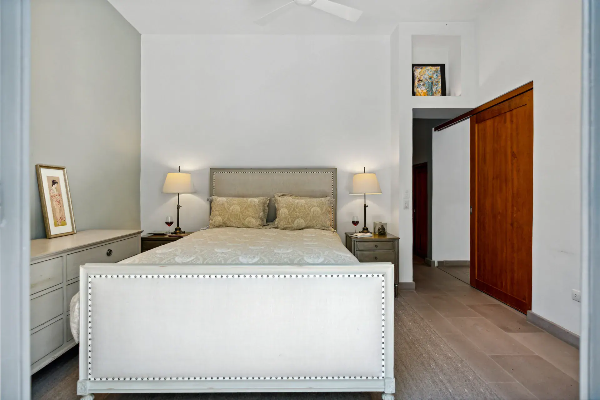Casa Lula, bedroom with a white upholstered bed and wood doors, San Miguel de Allende