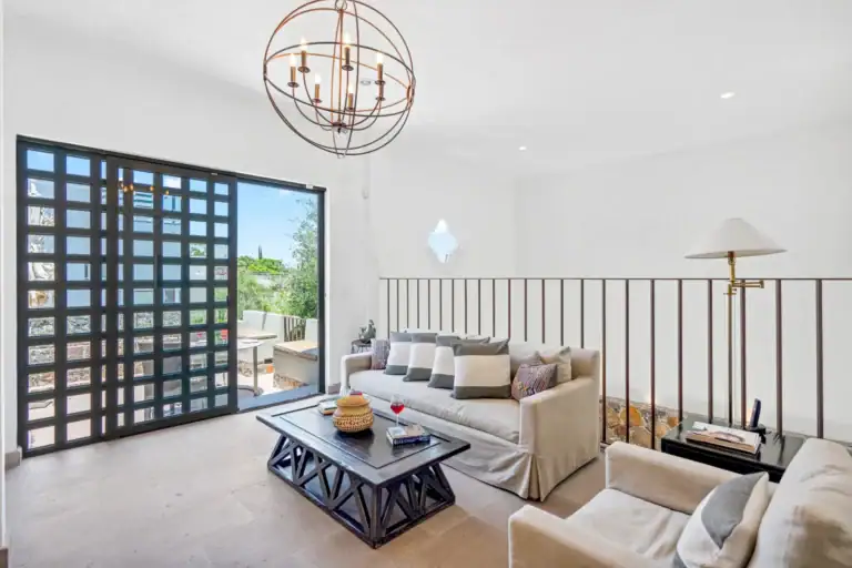 Casa Lula, upstairs sitting room with a sofa and a gridded glass door, San Miguel de Allende