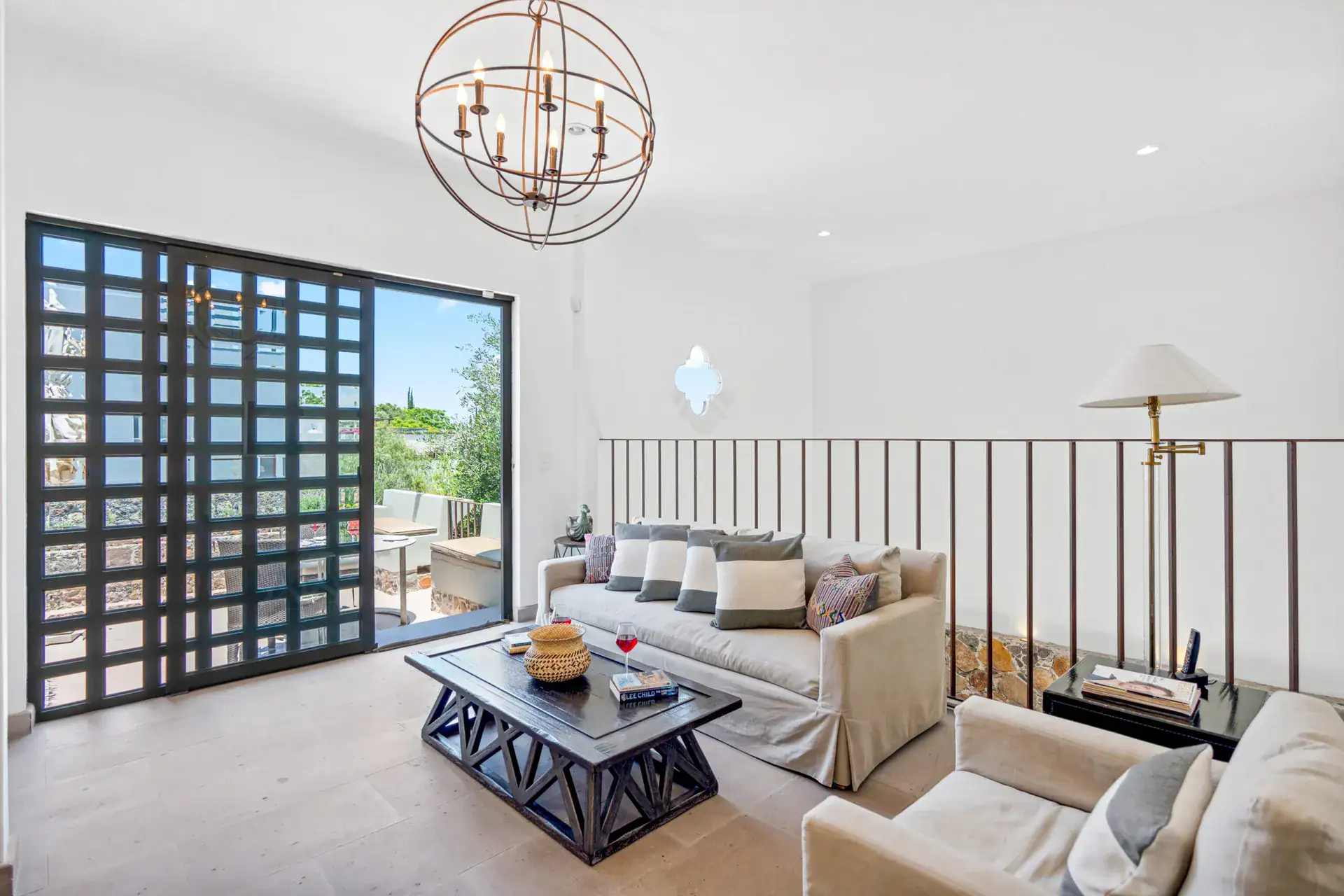 Casa Lula, upstairs sitting room with a sofa and a gridded glass door, San Miguel de Allende