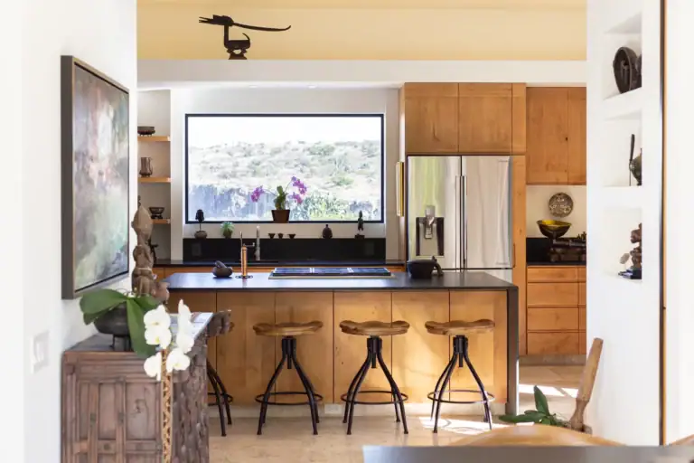 Casa Luz, kitchen with a wood island, black stools, stainless steel refrigerator and a window to the hills, San Miguel de Allende