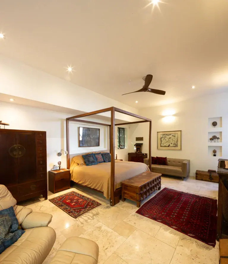 Casa Luz, bedroom with a four-poster bed, red rugs and a ceiling fan, San Miguel de Allende