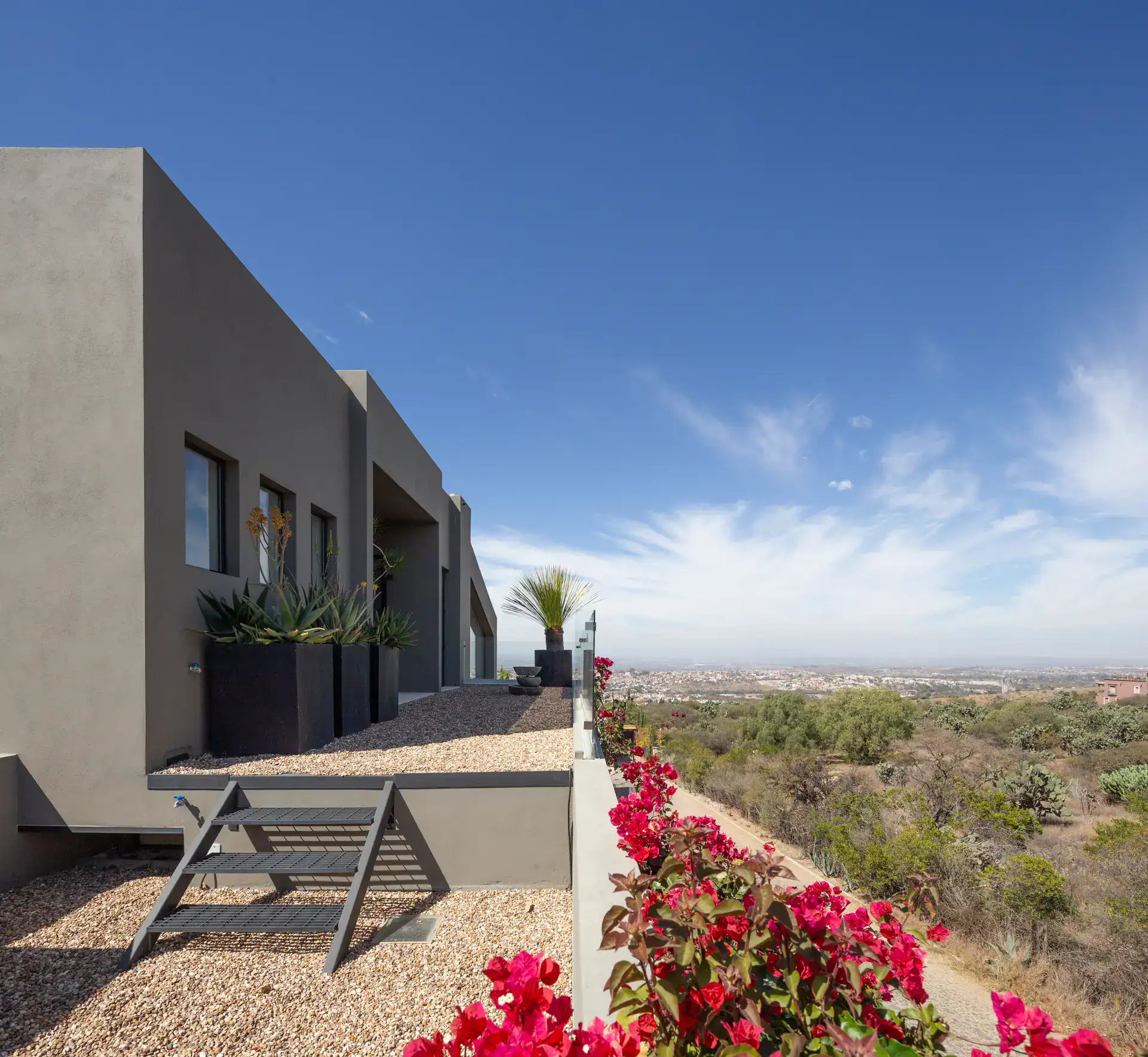 Casa Luz, rooftop terrace with a lounge chair, bougainvillea and a view over the valley, San Miguel de Allende