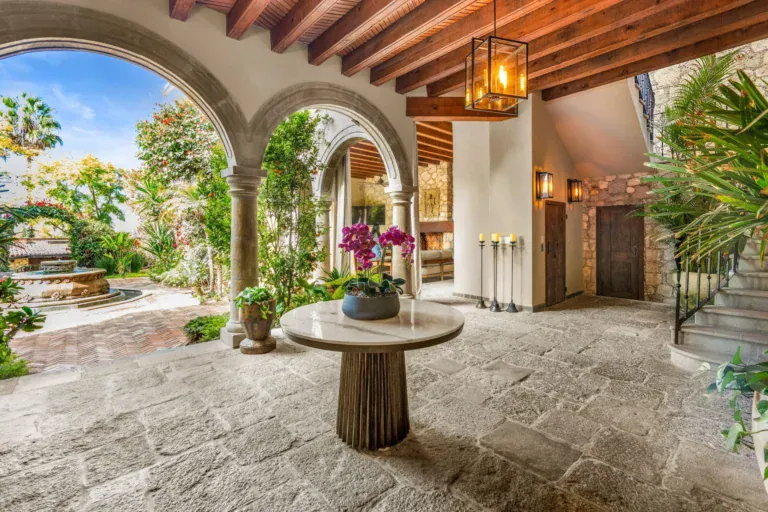 Casa Luz, stone entry courtyard with a round table and arched openings, San Miguel de Allende