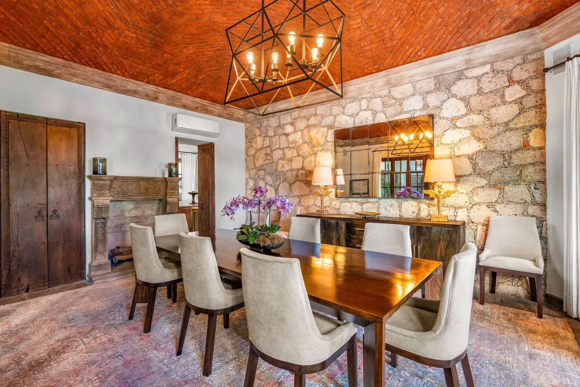 Casa Luz, dining room with a long wood table, stone wall and brick vaulted ceiling, San Miguel de Allende