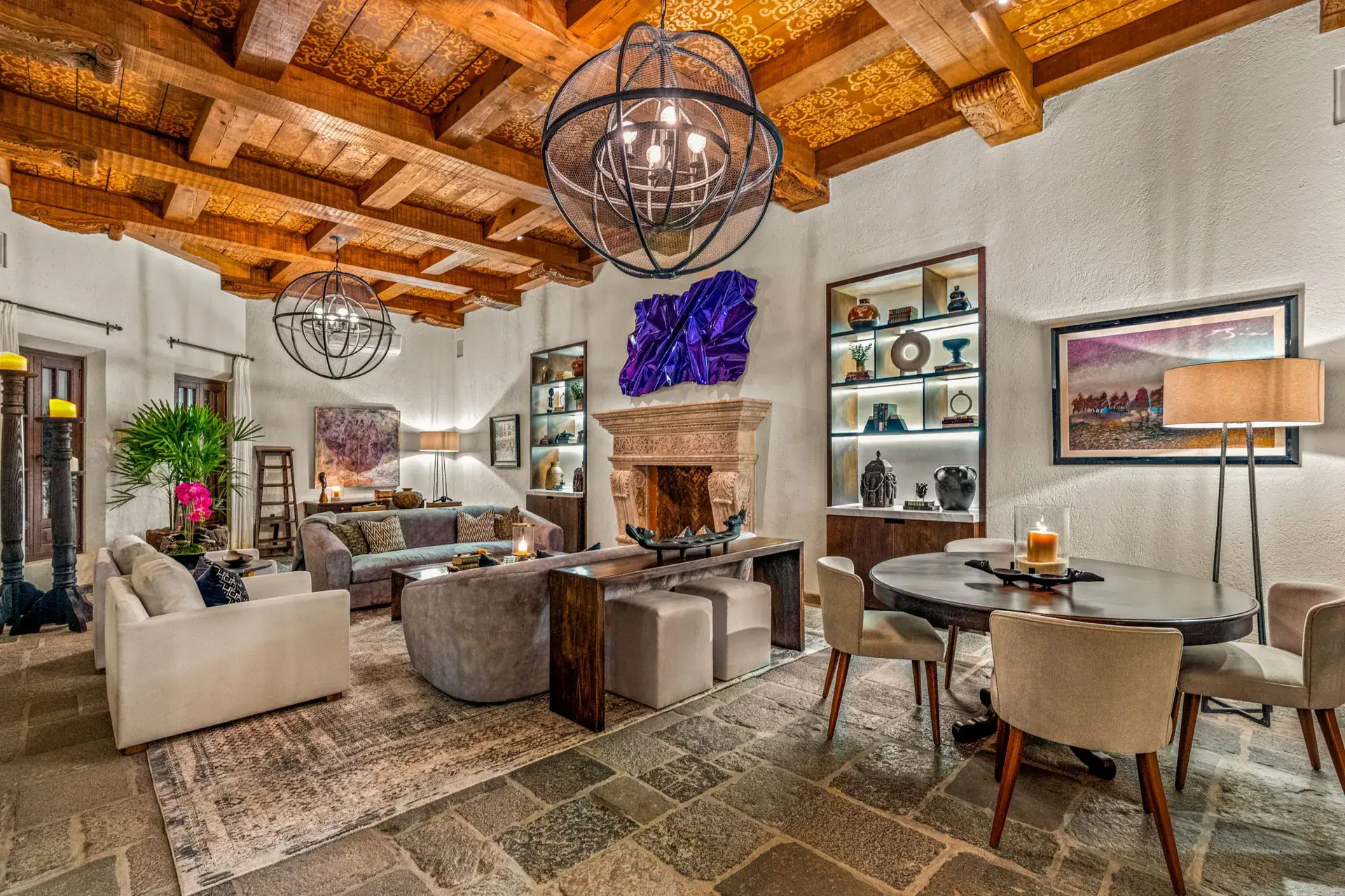 Casa Luz, great room with a stone fireplace, built-in shelves and a round chandelier, San Miguel de Allende