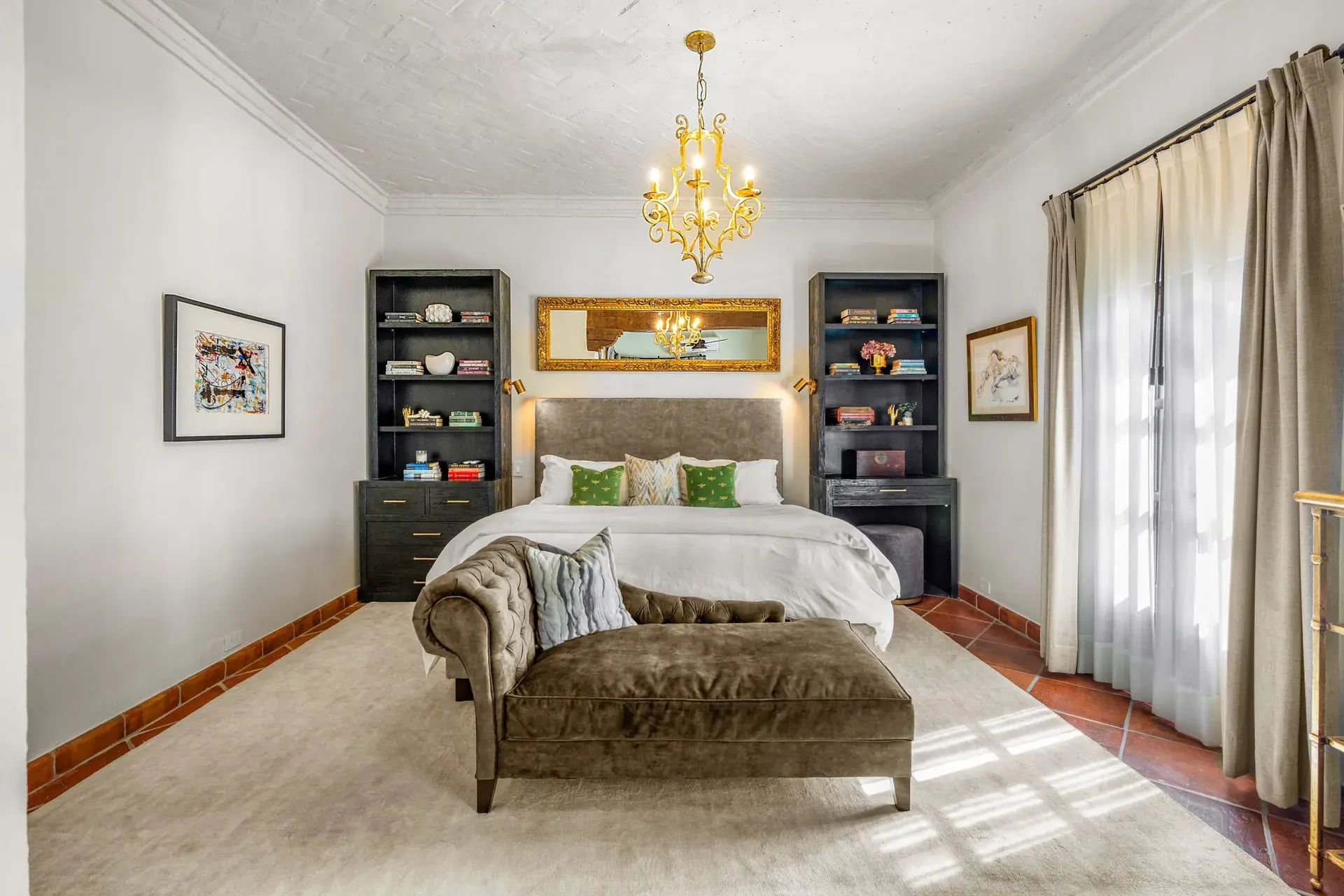 Casa Luz, primary bedroom with a tufted bench, chandelier and tall windows, San Miguel de Allende
