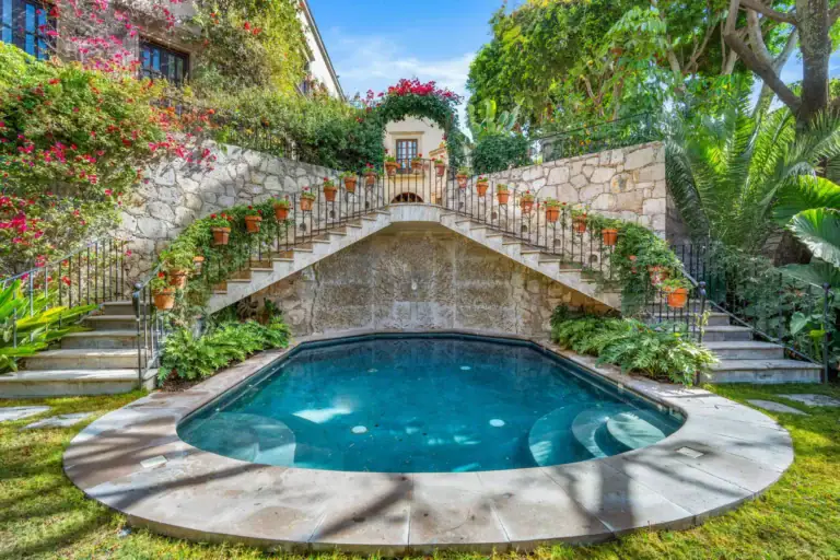 Casa Luz, courtyard pool beneath a curved stone staircase, San Miguel de Allende
