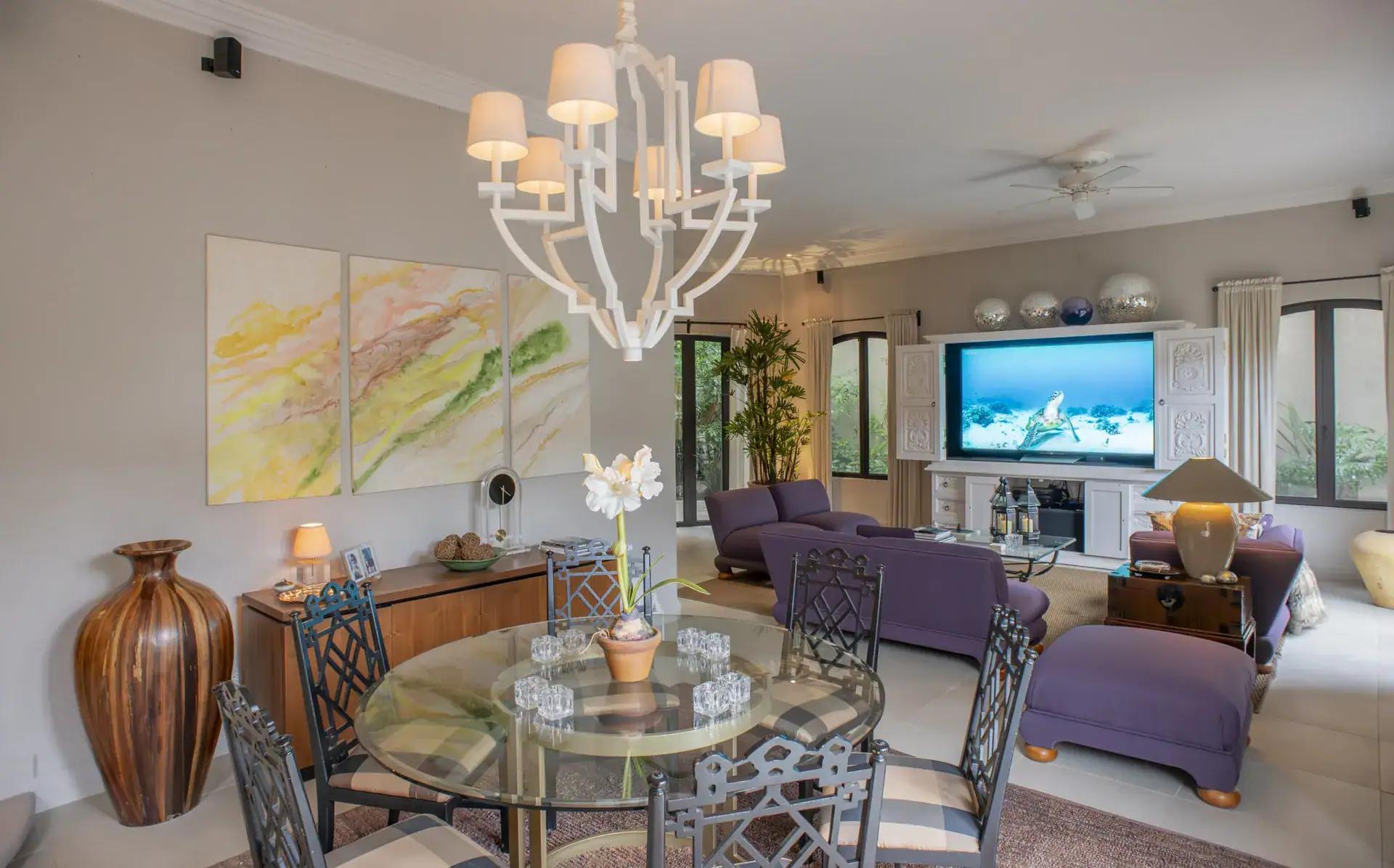 Casa Lyla, family room and dining area with a white chandelier, a glass dining table and purple seating, San Miguel de Allende
