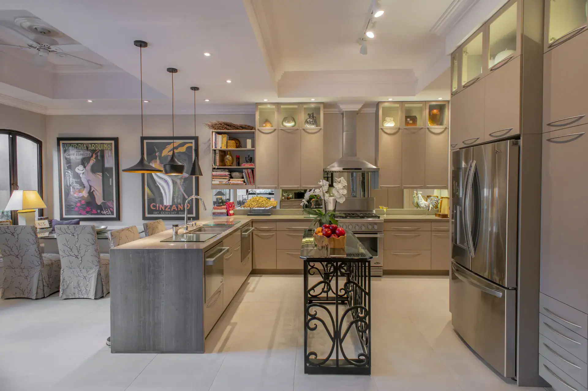 Casa Lyla, kitchen with a glass-top island on an iron base, a stainless refrigerator and pendant lights, San Miguel de Allende