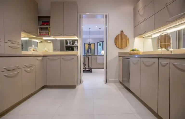 Casa Lyla, kitchen with taupe cabinets, mirrored backsplash and a view through to a hallway, San Miguel de Allende