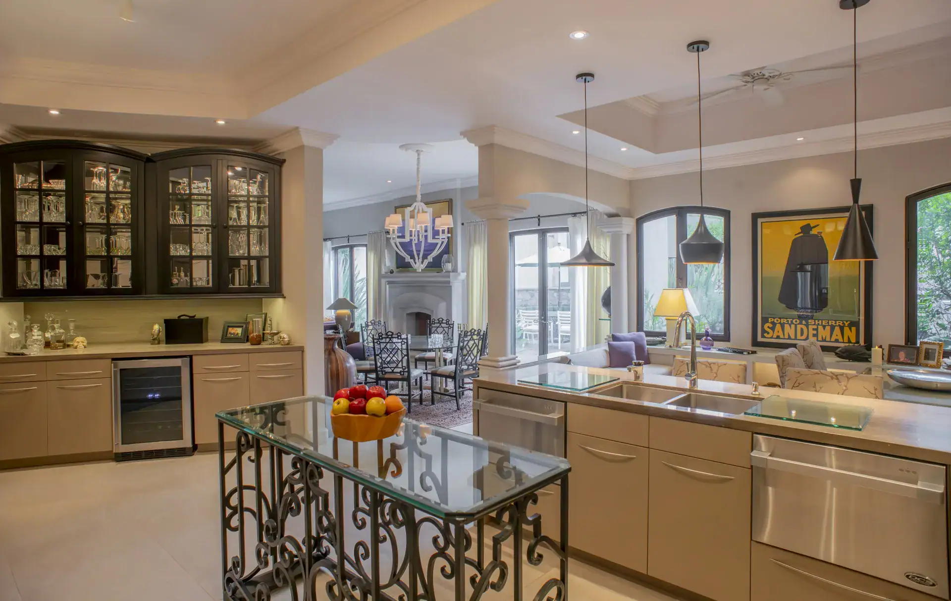 Casa Lyla, butler's pantry with glass-front cabinets, a wine fridge and an iron-base counter, opening to the dining area, San Miguel de Allende