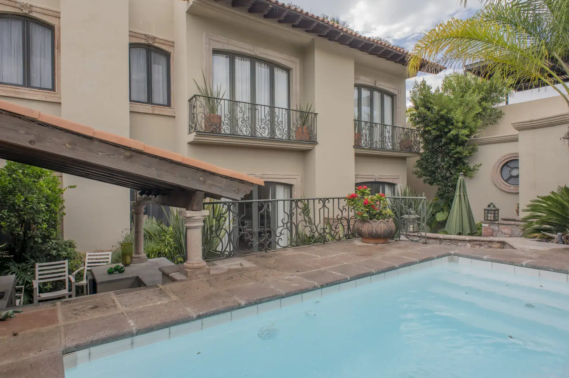 Casa Lyla, pool and a house facade with balconies and a wood pergola, San Miguel de Allende