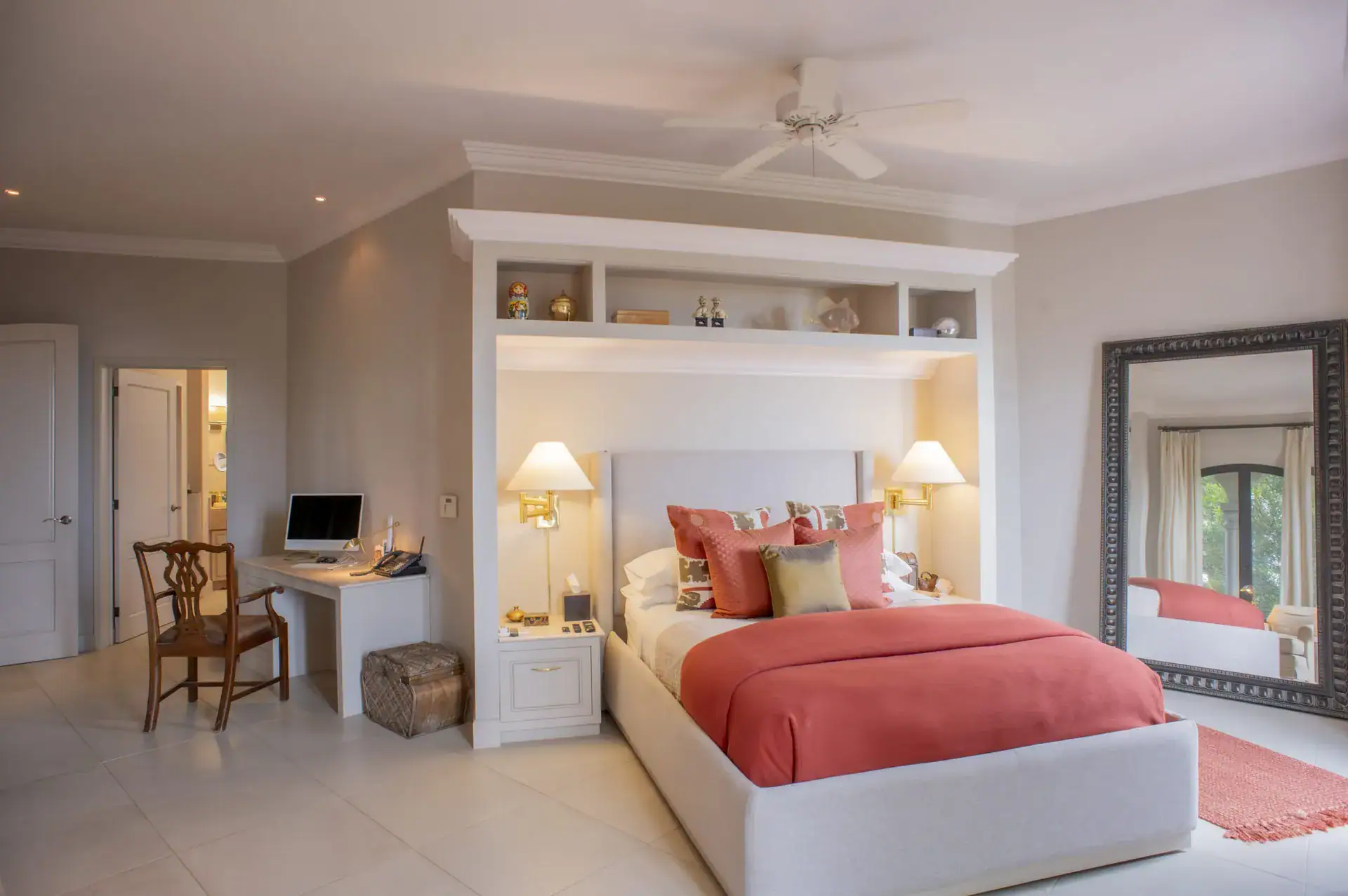 Casa Lyla, bedroom with a built-in white headboard unit, a coral bedspread and a desk, San Miguel de Allende