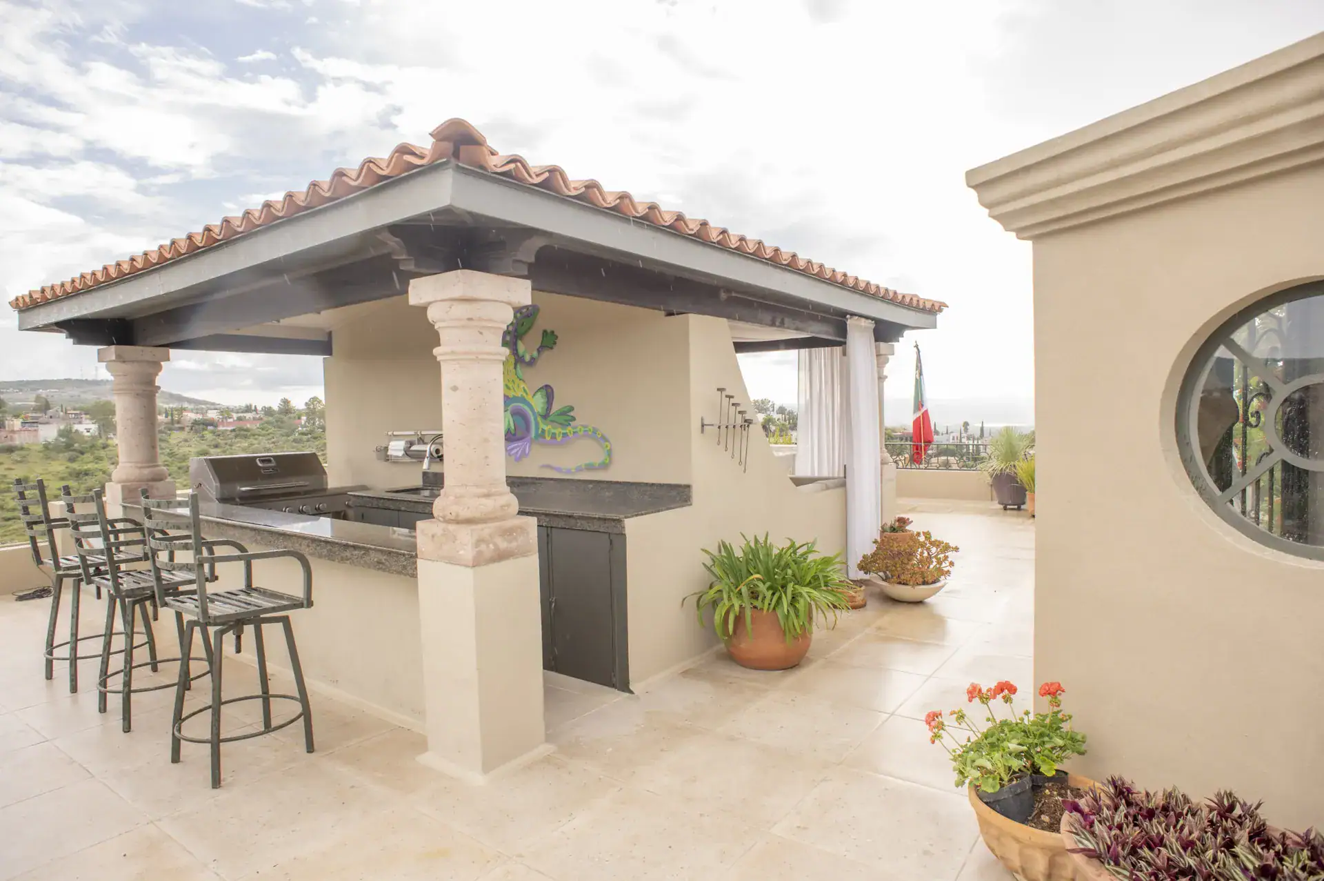 Casa Lyla, rooftop outdoor kitchen pavilion with a grill, bar stools and a gecko mural, San Miguel de Allende