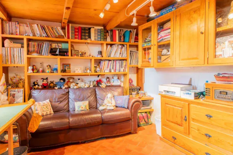 Casa Mexicana, library with wood bookshelves, a leather sofa, built-in cabinets and a sewing table, San Miguel de Allende