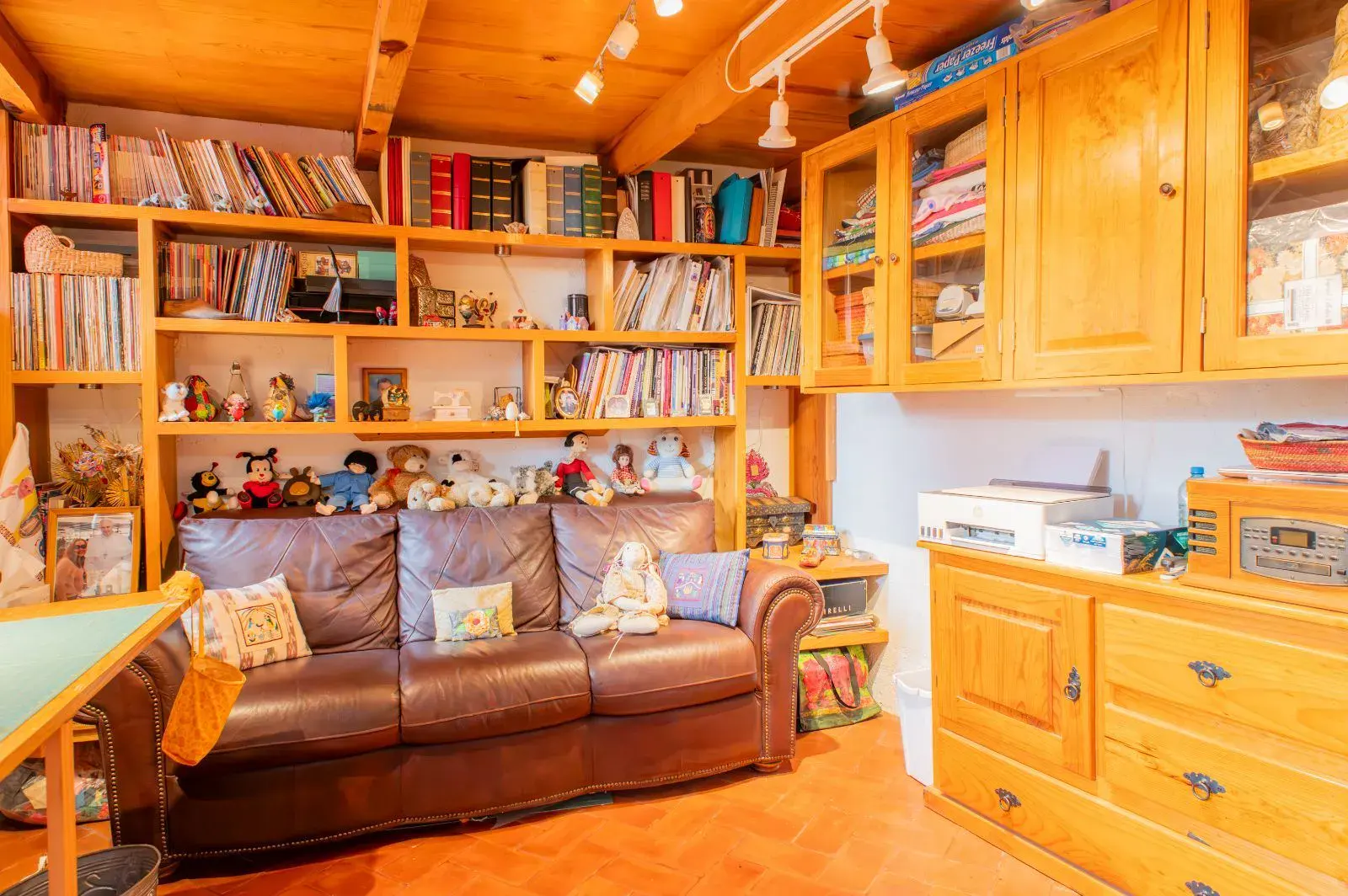 Casa Mexicana, library with wood bookshelves, a leather sofa, built-in cabinets and a sewing table, San Miguel de Allende