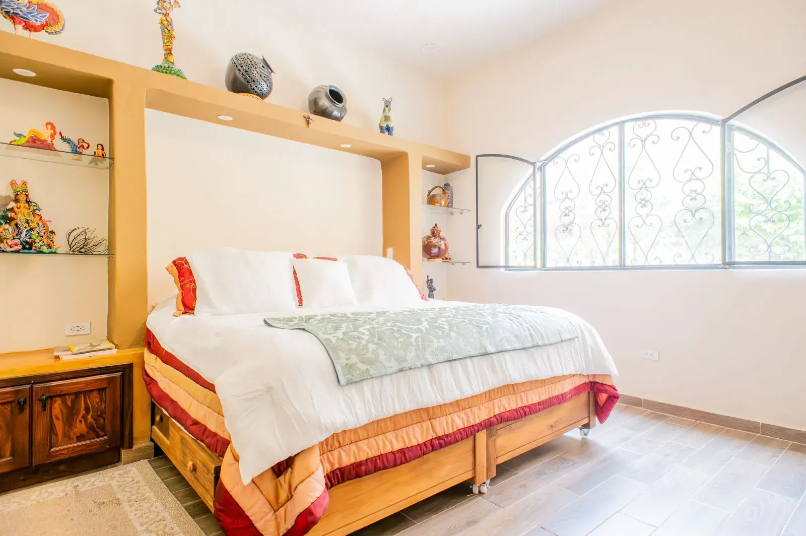 Casa Mexicana, bedroom with a king bed, wood storage drawers, an arched window and a built-in shelf, San Miguel de Allende