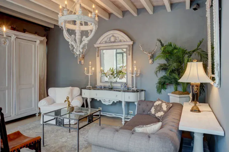 Casa Mi Besito, sitting room with a gray tufted sofa, white armchairs, a white console and a white chandelier, San Miguel de Allende