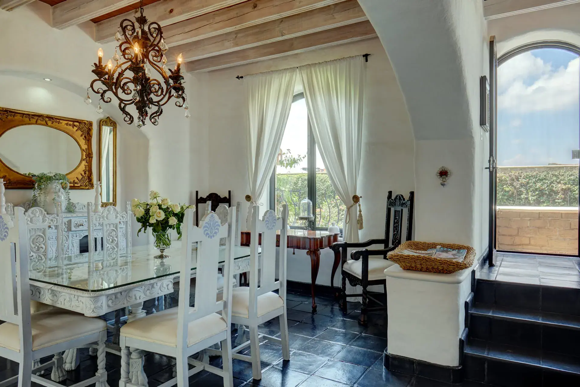 Casa Mi Besito, dining room with a gilded mirror, a white carved table and a window with a valley view, San Miguel de Allende