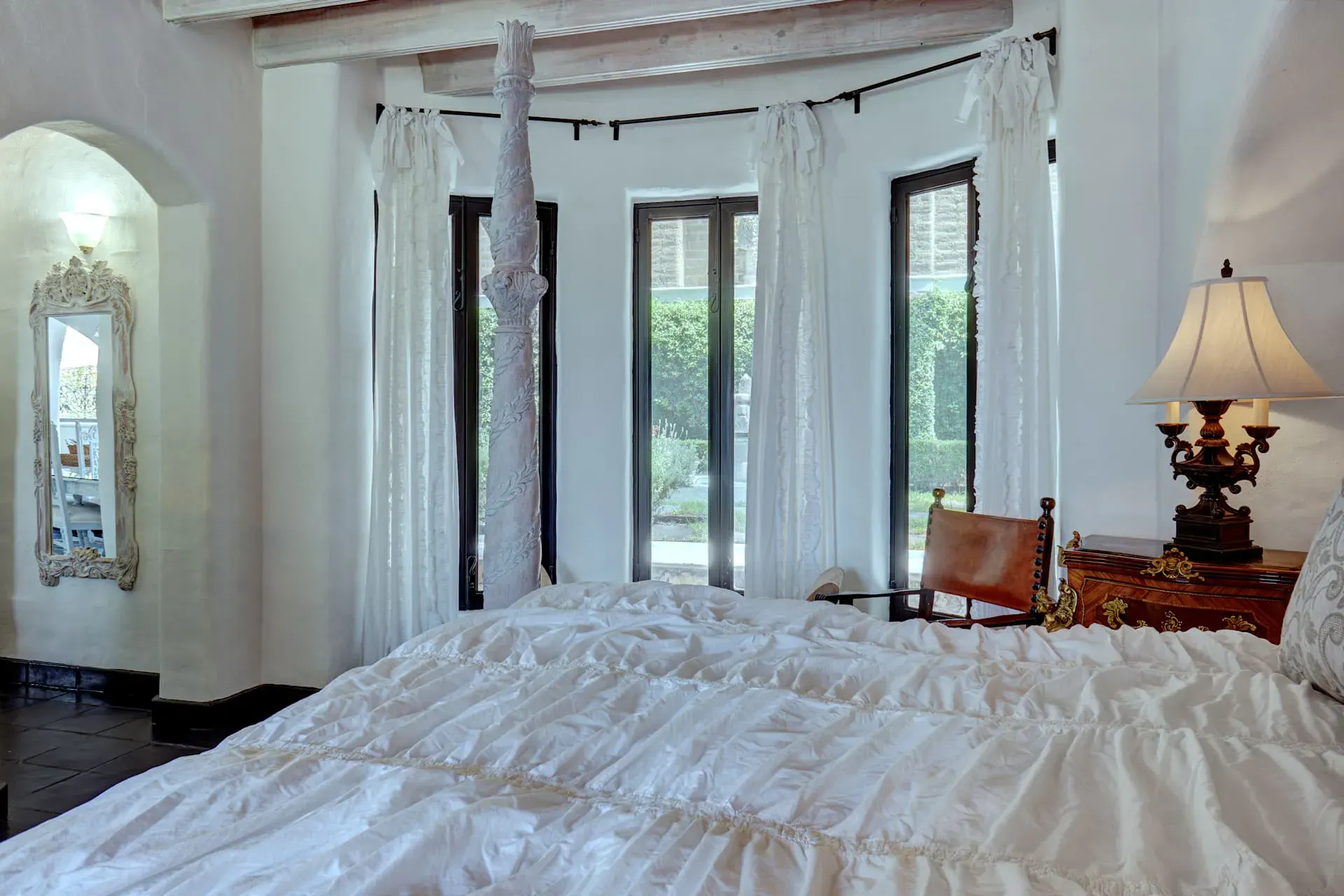 Casa Mi Besito, bedroom with a ruffled white bedspread, a bay window with curtains and a four-poster, San Miguel de Allende