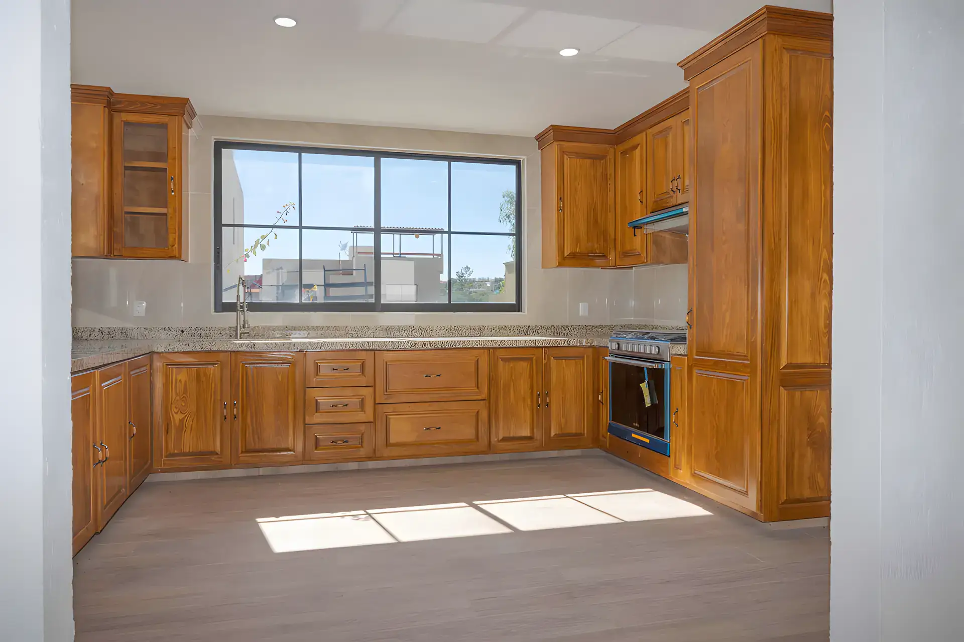 Casa Milagros, kitchen with wood cabinets, a granite counter, a gas range and a window, San Miguel de Allende