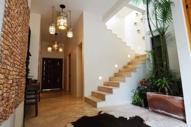 Casa Mojica, entry staircase with floating wood steps and hanging lanterns beside tropical plants, San Miguel de Allende