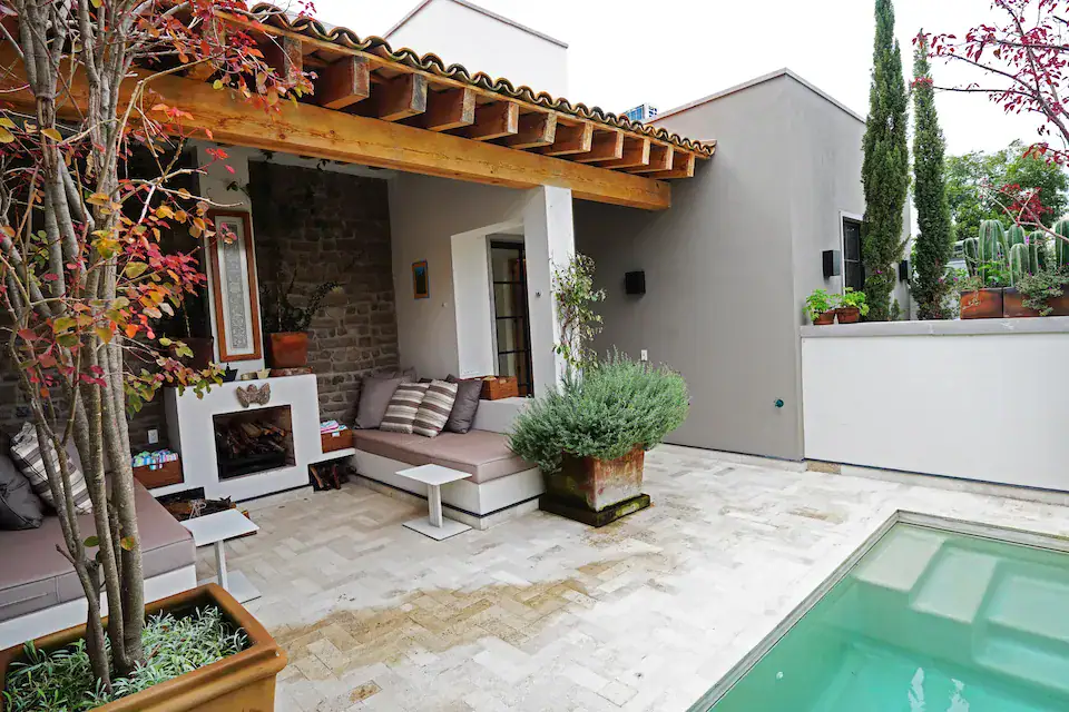 Casa Mojica, patio with a plunge pool, a fireplace and outdoor sofas under a tile roof, San Miguel de Allende
