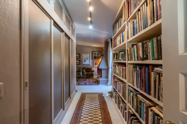 Casa Nispero, hallway lined with floor-to-ceiling bookshelves leading to a sitting room, San Miguel de Allende