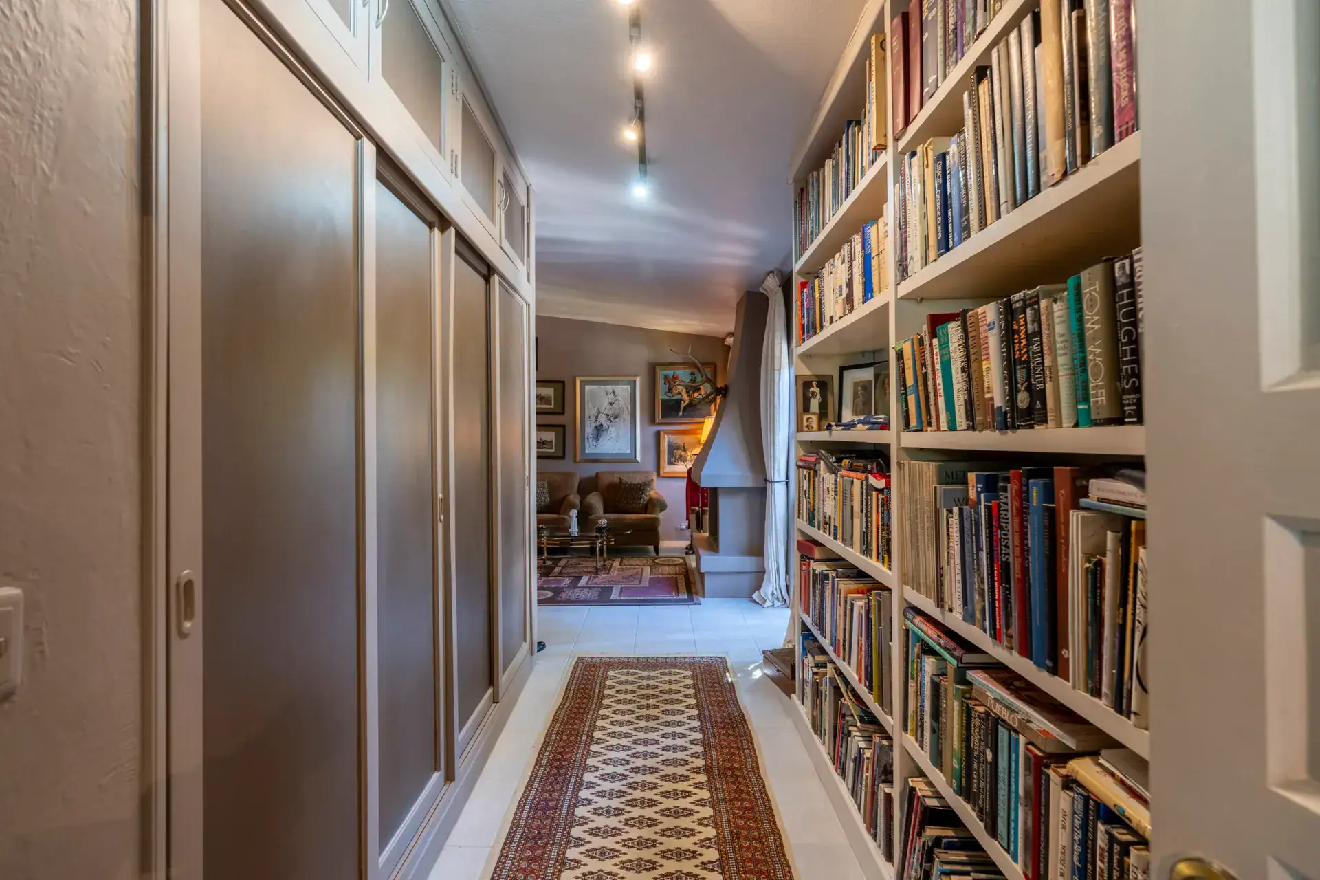 Casa Nispero, hallway lined with floor-to-ceiling bookshelves leading to a sitting room, San Miguel de Allende