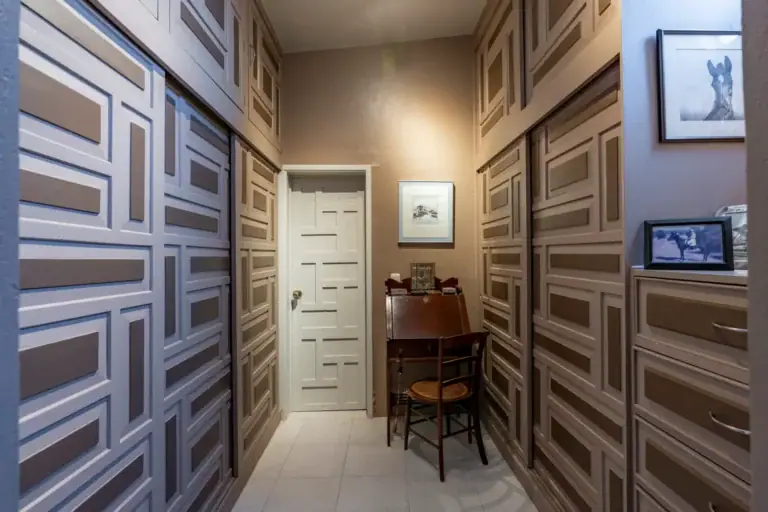 Casa Nispero, dressing room with gray paneled wardrobe doors, a white door and a small writing desk, San Miguel de Allende