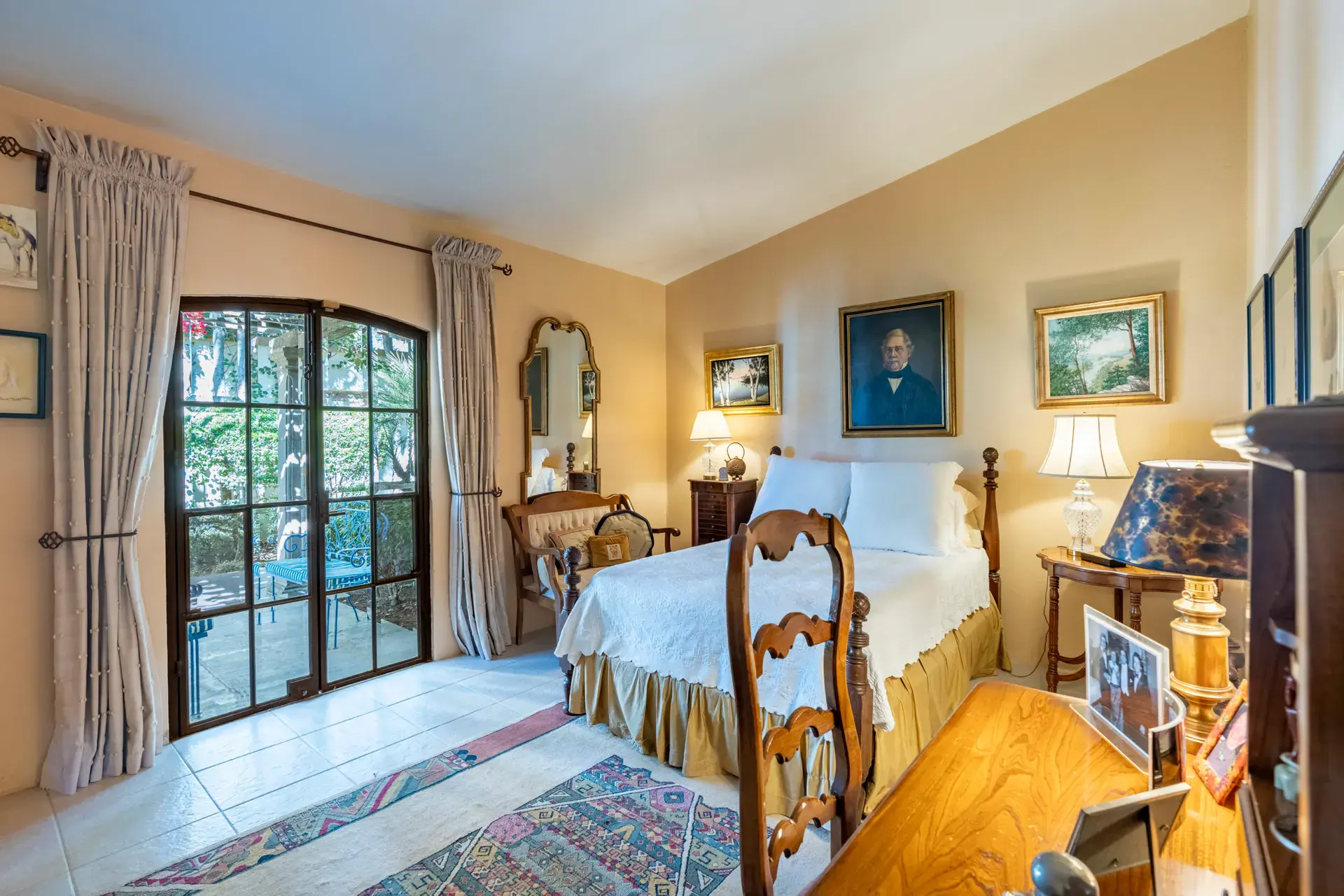 Casa Nispero, guest bedroom with a carved wood bed, a ladder-back chair and French doors to the patio, San Miguel de Allende