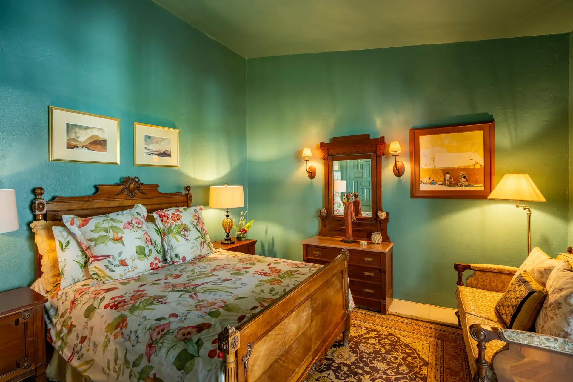 Casa Nispero, bedroom with teal walls, a carved wood bed with floral bedding and a framed landscape, San Miguel de Allende