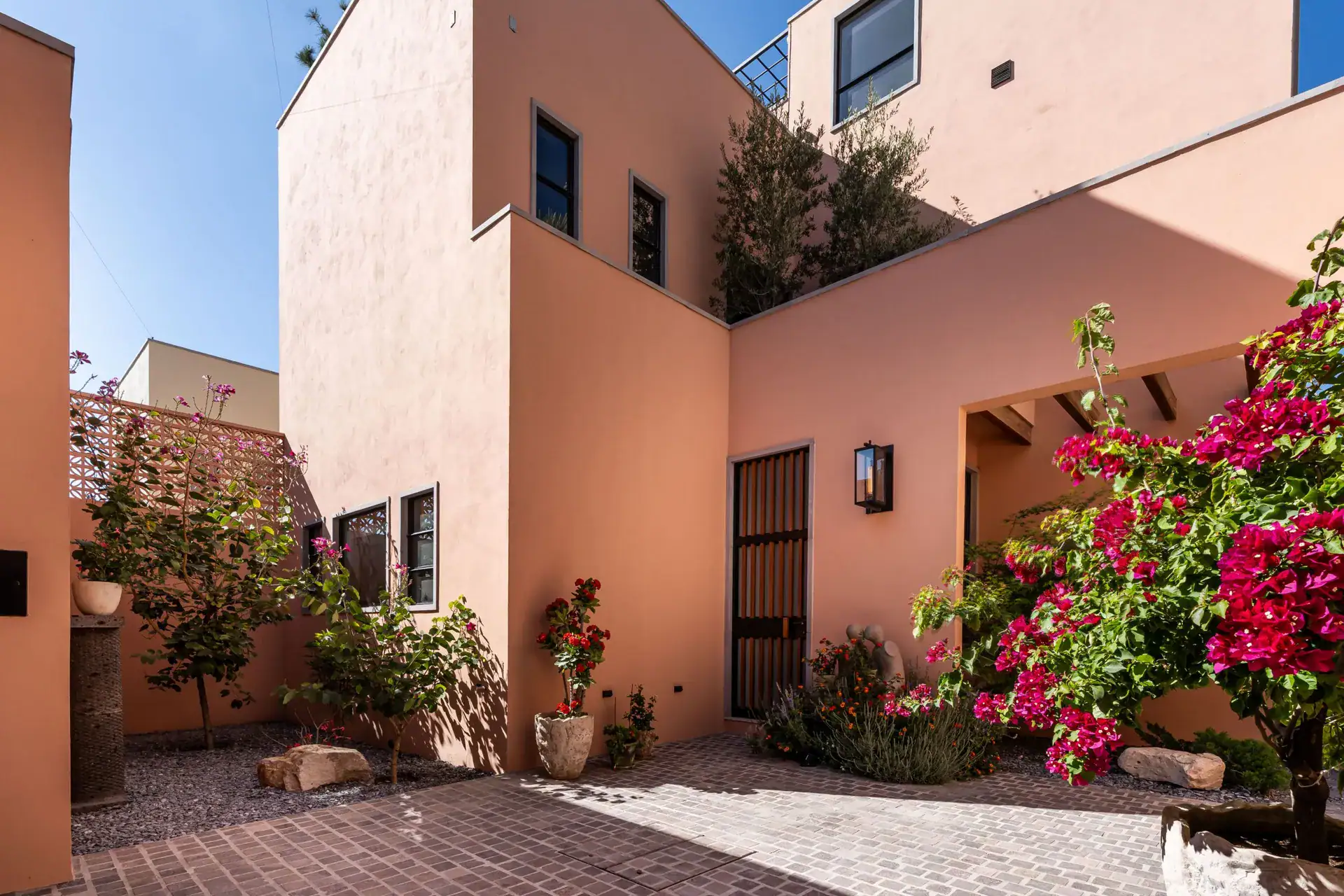 Casa Nobel, salmon-pink two-story house with a patio, bougainvillea and a black entry gate, San Miguel de Allende