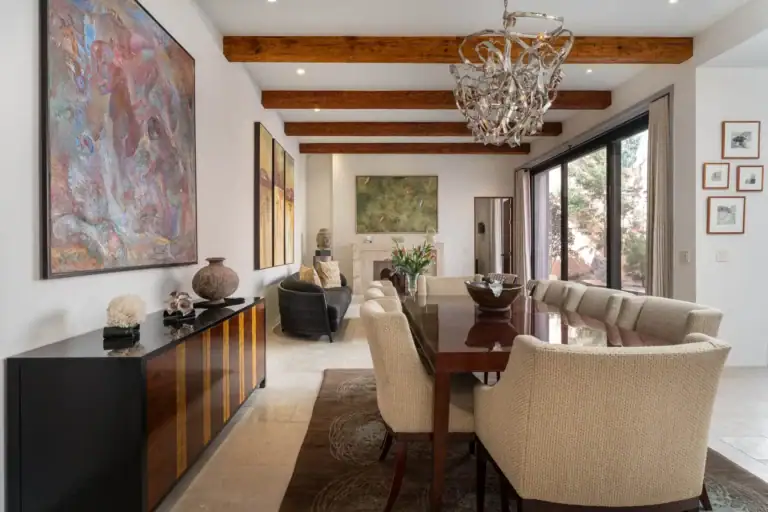 Casa Nobel, living and dining room with a large abstract painting, a wood sideboard and a chandelier, San Miguel de Allende