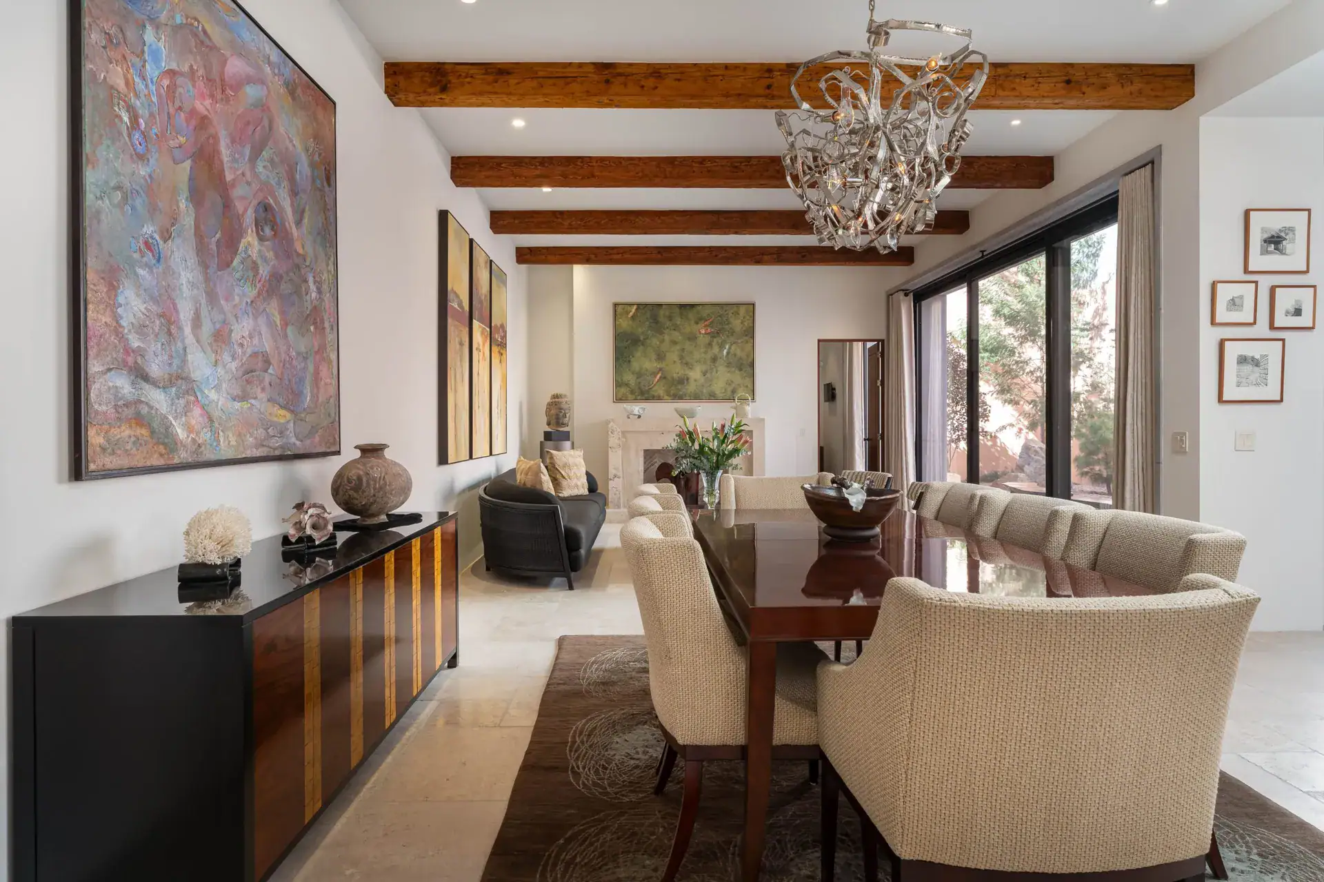 Casa Nobel, living and dining room with a large abstract painting, a wood sideboard and a chandelier, San Miguel de Allende