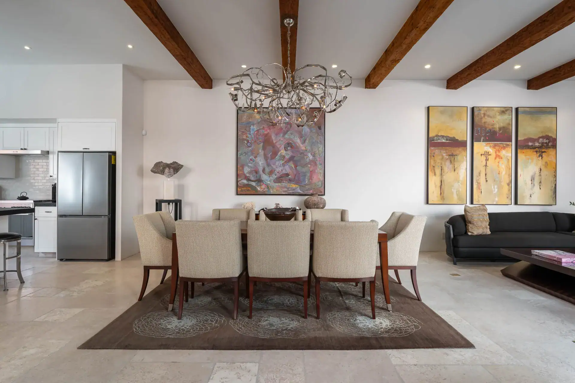 Casa Nobel, dining table with cream chairs, a large painting and a black sofa in the living room, San Miguel de Allende